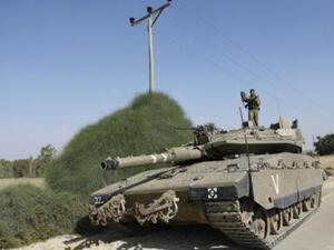 جندي اسرائيلي يقف على دبابة ميركافا على الحدود الاسرائيلية مع قطاع غزة
