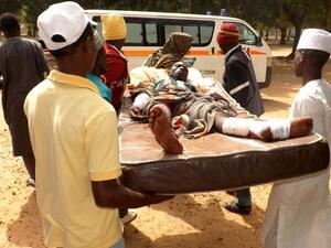Relatives carry a man injured in a suicide blast in the northeast Nigerian town of Potiskum on Jan. 12. No one claimed responsibility but the attacks bore the hallmark of Boko Haram militants. (AFP/Aminu Abubakar)