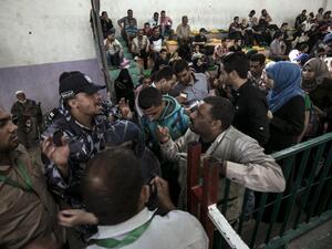 Palestinians residing in the Gaza Strip wait for a travel permit to cross into Egypt through the Rafah border crossing. (AFP/Said Khatib)
