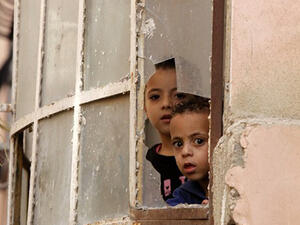 Palestinian children look through a window at Israeli soldiers conducting searches in the Palestinian al-Fawwar refugee camp, south of the West Bank city of Hebron. (AFP/File)