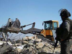 An Israeli soldier stands as a bulldozer pulls down the house of a Palestinian family near the West Bank town of Hebron. (AFP/Hazem Bader) An Israeli soldier stands as a bulldozer pulls down the house of a Palestinian family near the West Bank town of Hebron. (AFP/Hazem Bader)