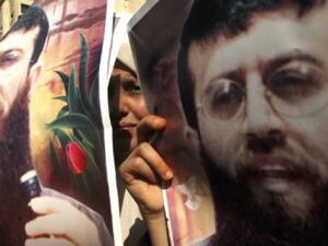 Palestinian protesters hold portraits of Mohammed Allaan, who ended his hunger strike on Thursday after more than two months of fasting. (AFP/File)