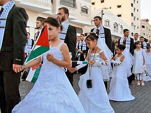 Photos of girls walking with the grooms of Gaza mass weddings are often mistaken as brides by the media. (Twitter)