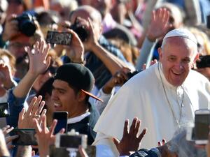 Pope Francis salutes the crowd as he arrives for his general audience in St Peter's square at the Vatican on October 5, 2016. (AFP/Vincenzo Pinto)