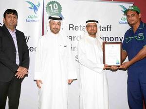 Abdulraoof Abdulaziz honors a staff member in the presence of Abdulla Hassan Al Noman and Ali Khan