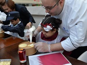 قام منتسبو الجمعية بتلوين البسكويت بألوان العلم القطري احتفاءاً بهذه المناسبة