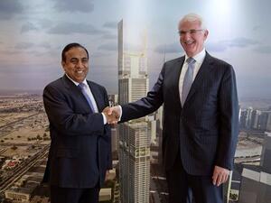 من اليمين السيد جيرالد لوليس، الرئيس والرئيس التنفيذي لمجموعة جميرا يتصافح مع الدكتور رافي بيلاي، رئيس مجلس إدارة مجموعة شركات آر بي، الشركة القابضة لـ آر بي جلوبال أمام صورة مشروع جميرا الخليج التجاري الواقع ضمن برج آر بي جلوبال الذي سيتم انشاءه في دبي.