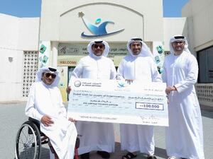 راشد علي الأنصاري، مدير عام شركة "الأنصاري للصرافة" أثناء تسليمه مبلغ الدعم لثاني جمعة ثاني بالرقاد، رئيس مجلس إدارة نادي دبي لأصحاب الهمم.