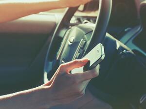 Even touching your mobile phone while driving will be considered a traffic violation for which motorists will be fined SR150. (Shutterstock)