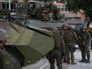 أظهر التلفزيون البرازيلي الجنود المسلحين ببنادق آلية يجلسون أعلى دبابات