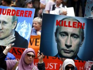 متظاهرون في العاصمة الاسترالية سيدني يحملون صورا كتبت عليها عبارات تندد بالرئيس الروسي على خلفية تدخل بلاده العسكري في سوريا
