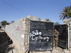 كتابة على جدران وبوابة منزل تحذر من الألغام في مدينة الرمادي 
