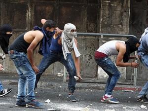 Palestinian youths throw stones towards Israeli security forces during clashes in the West Bank town of Hebron on October 4, 2015. (AFP/File) Palestinian youths throw stones towards Israeli security forces during clashes in the West Bank town of Hebron on October 4, 2015. (AFP/File)