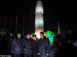 A group of men stand before an ice sculpture depicting a Hwasong-15 intercontinental ballistic missile (ICBM) at the Pyongyang Ice Sculpture Festival on New Year's Eve. (AFP) 