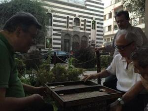 Tourist shop owners play backgammon on Damascus Straight Street (TCF)