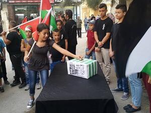 رفع الأطفال الذين تجمعوا أمام "نادي إبداع" قرب مدينة بيت لحم جنوبي الضفة الغربية لافتات داعمة للنادي الأسكتلندي،