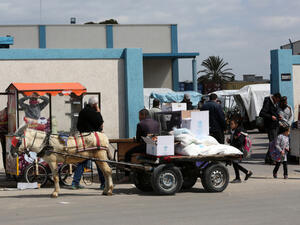 Palestinians receive aid packs from the United Nations Relief and Works Agency for Refugees (UNRWA) (Shutterstock)	