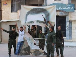 مقاتلون أكراد يمزقون صورة لبشار الأسد في القامشلي - عنب بلدي