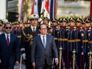 Egyptian President Abdelfattah al-Sisi and his French counterpart Francois Hollande review the honour guard during a welcome ceremony at the al-Quba presidential palace in Cairo on April 17, 2016. (AFP/Khaled Desouki)