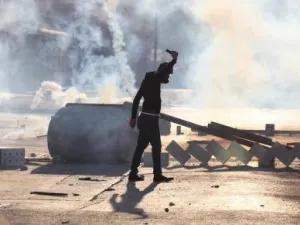 محتج يرتدي قناعا واقيا من الغاز يشارك في مظاهرات مناهضة للحكومة البحرينية في بلدة سترة جنوب المنامة
