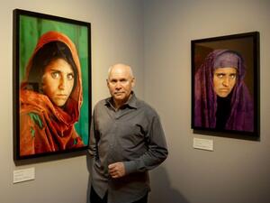 Photographer Steve McCurry poses next to his two portraits of Sharbat Gula, the 'Afghan Girl' from the famous National Geographic magazine cover in 1985. (AFP/File)