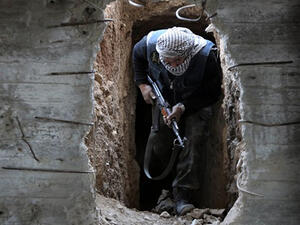 A Syrian rebel fighter from the Failaq al-Rahman brigade comes out of a hiding position on the frontline against regime forces in the town of Arbin in the eastern Ghouta region on the outskirts of the capital Damascus. (AFP/File)