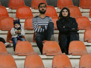 Fans attend a football game between Latakia's Hutteen and Hama's Taliya as part of the Syrian league at the Tishreen Sport City Stadium in Damascus. (AFP/File)