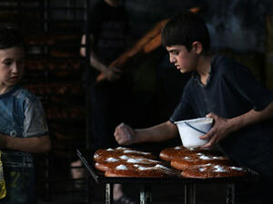 Syrian children help to prepare bread at a bakery in the rebel-held side of the northern city of Aleppo as Muslims get ready for Iftar during the holy month of Ramadan. (AFP/File)