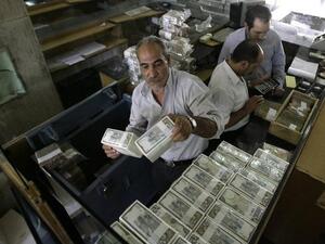 A banker stacks packed Syrian lira bills at the Central Bank in Damascus in 2011. (AFP/File) 