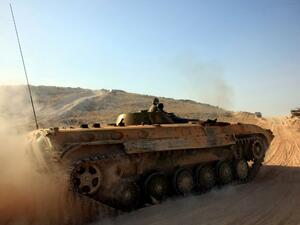 Syrian government forces drive a tank on a road during a military operation against Daesh in the villages of Zarour and Khanaser, in the Aleppo governorate, on February 26, 2016. (AFP/Georges Ourfalian)