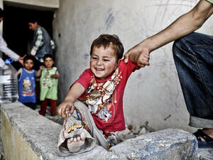 A Syrian man holds his infant in front of a disused house on June 28, 2014 in the Fikirtepe area of Istanbul. (AFP/File)