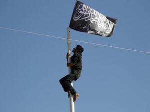 عضو في جبهة النصرة يتسلق سارية علم رفع في ميدان عام في سوريا بعد السيطرة عليه يوم 29 مايو ايار 2015
