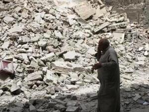 رجل يسير وسط حطام مبنى دمر بعد غارة جوية على حلب
