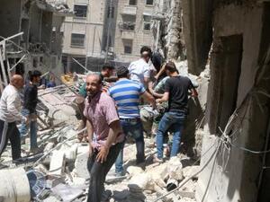 رجال في موقع تعرض لقصف في منطقة خاضعة لسيطرة المعارضة في حلب
