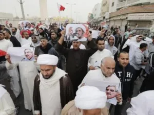 محتجون يحملون صورا للشيخ علي سلمان زعيم جمعية الوفاق أثناء مظاهرة في المنامة

