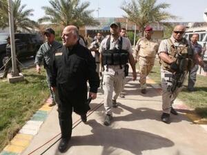 رئيس الوزراء العراقي حيدر العبادي (يسارا) لدى زيارته لمعسكر طارق بالقرب من الفلوجة يوم الاربعاء
