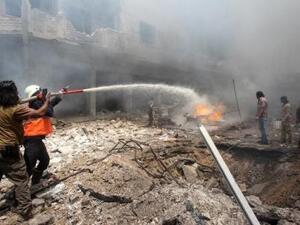 أشخاص يحاولون إطفاء حريق بعد ضربة جوية على إدلب يوم الاحد
