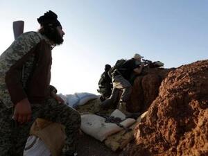 مقاتل من "جيش السنة" يقف عند نقطة مراقبة في ريف حلب الجنوبي بسوريا
