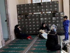 نساء سوريات يجلسن عند مدخل أحد المساجد في ازمير بتركيا
