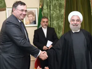 Total Chief Executive Officer Patrick Pouyanne (L) shakes hands with Iranian President Hassan Rouhani during a meeting in Paris on January 28, 2016. (Eric Fefferberg/ AFP)