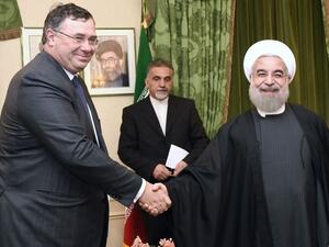 Total Chief Executive Officer Patrick Pouyanne (L) shakes hands with Iranian President Hassan Rouhani during a meeting in Paris on January 28, 2016. (Eric Fefferberg/ AFP)