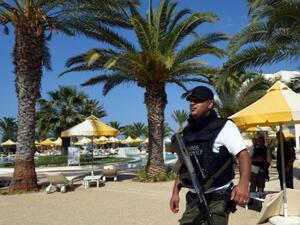 A Tunisian security official stands guard by a resort pool. (AFP/Fethi Belaid)
