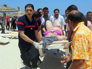 Tunisian medics carry a woman on a stretcher in the resort town of Sousse after an IS-related attack on June 27, 2015. The attack killed nearly 40 people, most of them British tourists. (AFP)