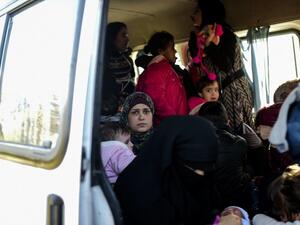 A woman looks on from inside a van after being detained by Turkish soldiers with other Syrians trying to reach the Greek island of Lesbos from Dikili, western Turkey, on March 5, 2016. (AFP/Bulent Kilic)