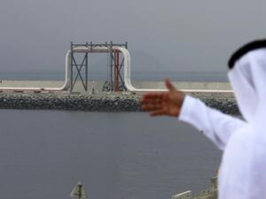 An Emirati man stands in front of a pipeline at the oil terminal of Fujairah during the inauguration ceremony of a dock for supertankers on September 21, 2016. (Karim Sahib/ AFP)