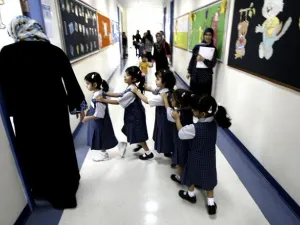 Students line up as they enter their classroom on the first day of the academic year for public schools in Dubai on September 27, 2009. (Karim Sahib/ AFP)
