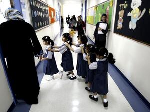 Students line up as they enter their classroom on the first day of the academic year for public schools in Dubai on September 27, 2009. (Karim Sahib/ AFP)