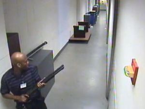 تظهر اللقطات آرون ألكسيس وهو يسير في ممر بمقر للبحرية وهو يحمل سلاحا ناريا