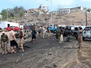 Pro-Hadi loyalist forces and civilians examine the aftermath of a suicide bombing in Aden. (AFP/Saleh al-Obeidi)