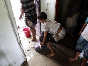 A boy helps clear the floodwaters from his home in Sanaa, Yemen. (AFP/Mohammed Huwais)